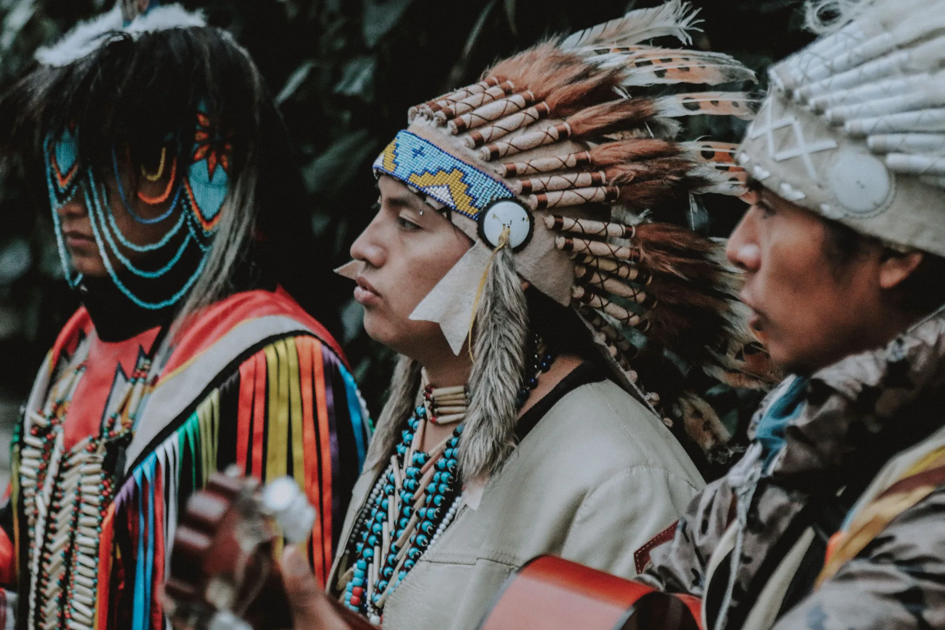 Indigenous community members in ceremonial regalia